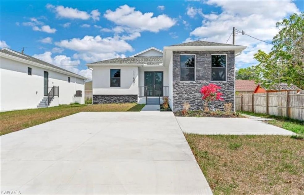 View of front of home featuring stone siding, french doors, and stucco siding