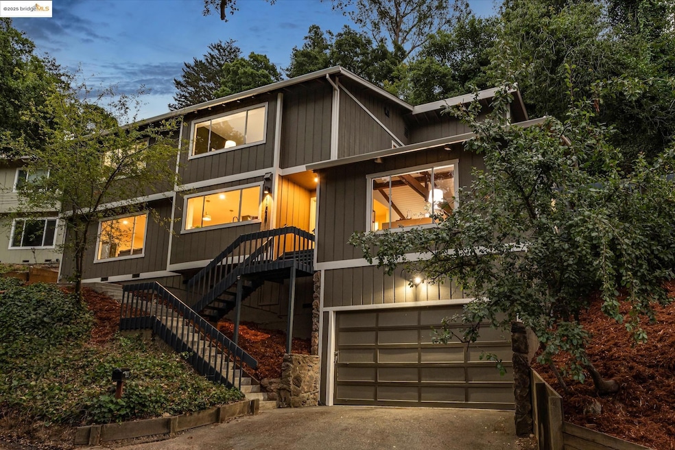 View of front facade featuring a garage, concrete driveway, and stairway