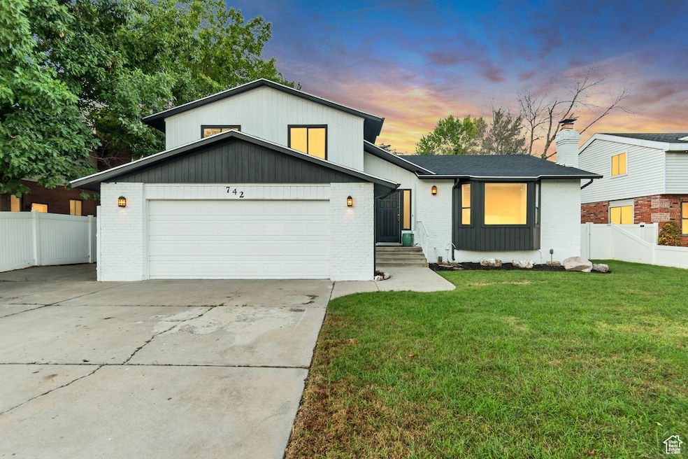 View of front facade featuring brick siding and concrete driveway