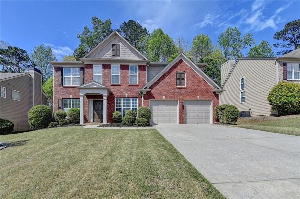 View of front of property featuring a garage, bric