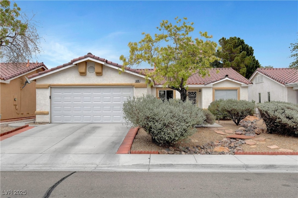 View of front of house featuring driveway, an atta