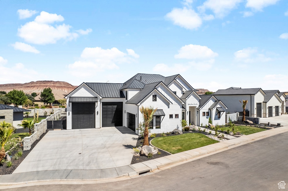 Modern farmhouse featuring concrete driveway, an attached garage, a metal roof, a standing seam roof, and a residential view