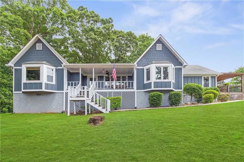 View of front of home with board and batten siding, stairs, a ceiling fan, and a front yard