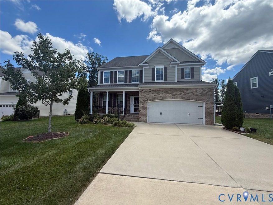View of front of home featuring a porch, a garage, a front yard, and driveway