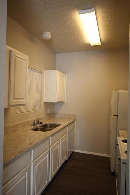 Kitchen featuring range, dishwasher, dark wood fi