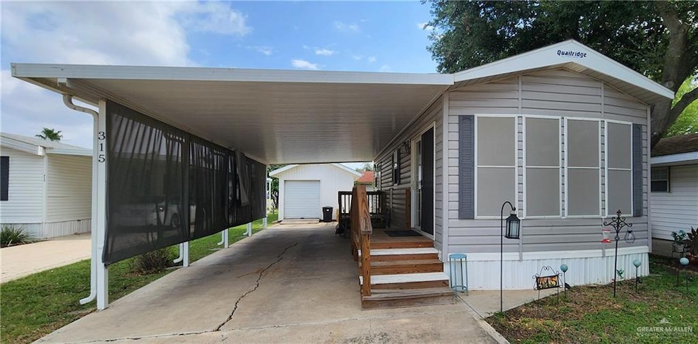 Manufactured / Park model home with an outdoor structure and a carport