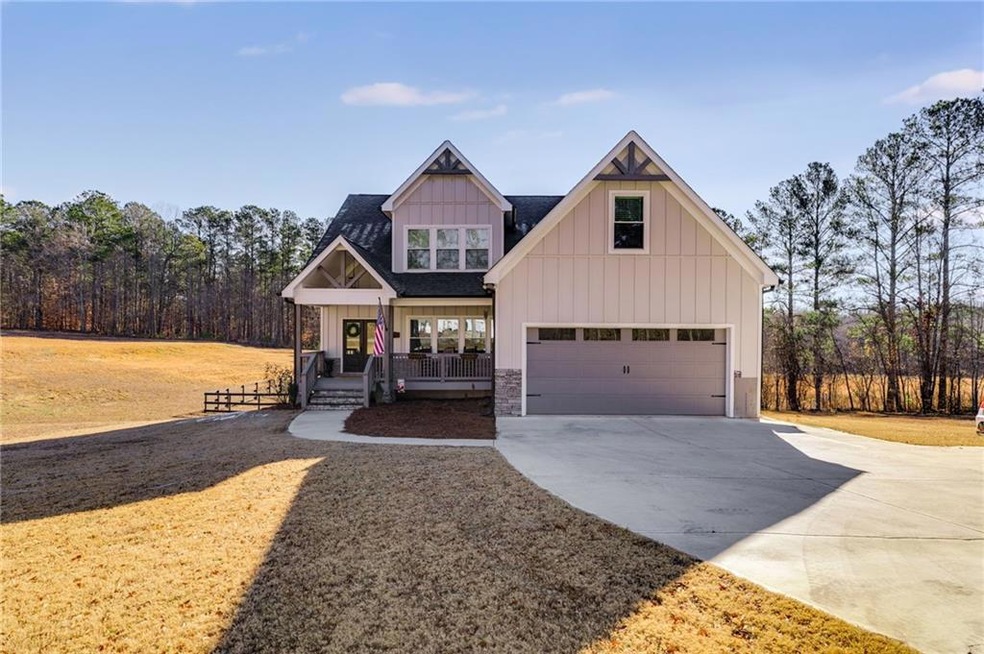 View of front of property featuring a porch, a gar