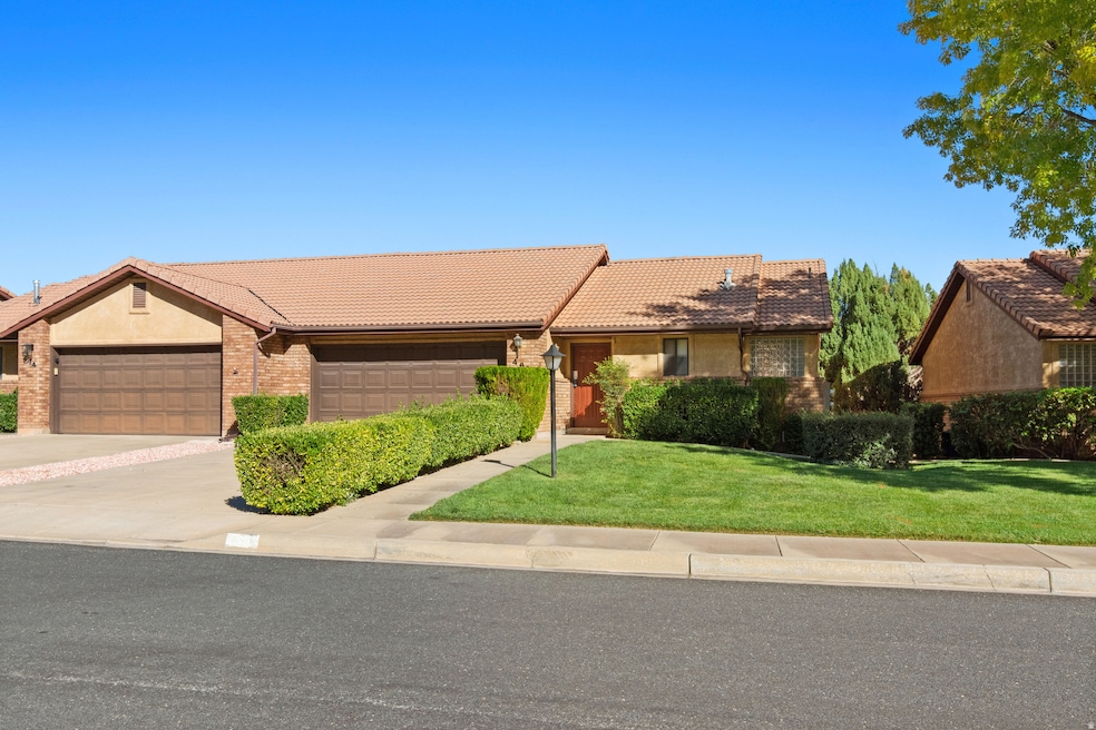 Single story home featuring a front lawn, a tile roof, concrete driveway, an attached garage, and brick siding
