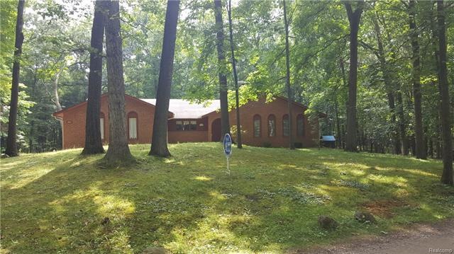 Nestled in a wooded 2.46 acres with brick arches a