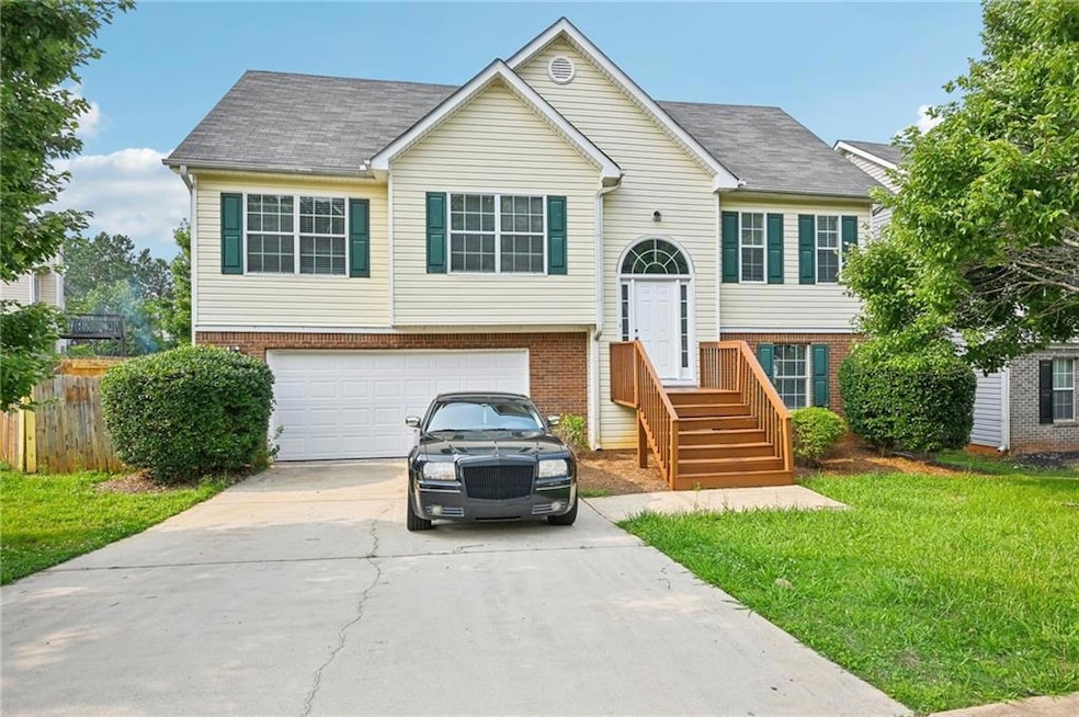 Raised ranch featuring concrete driveway, brick siding, an attached garage, and roof with shingles