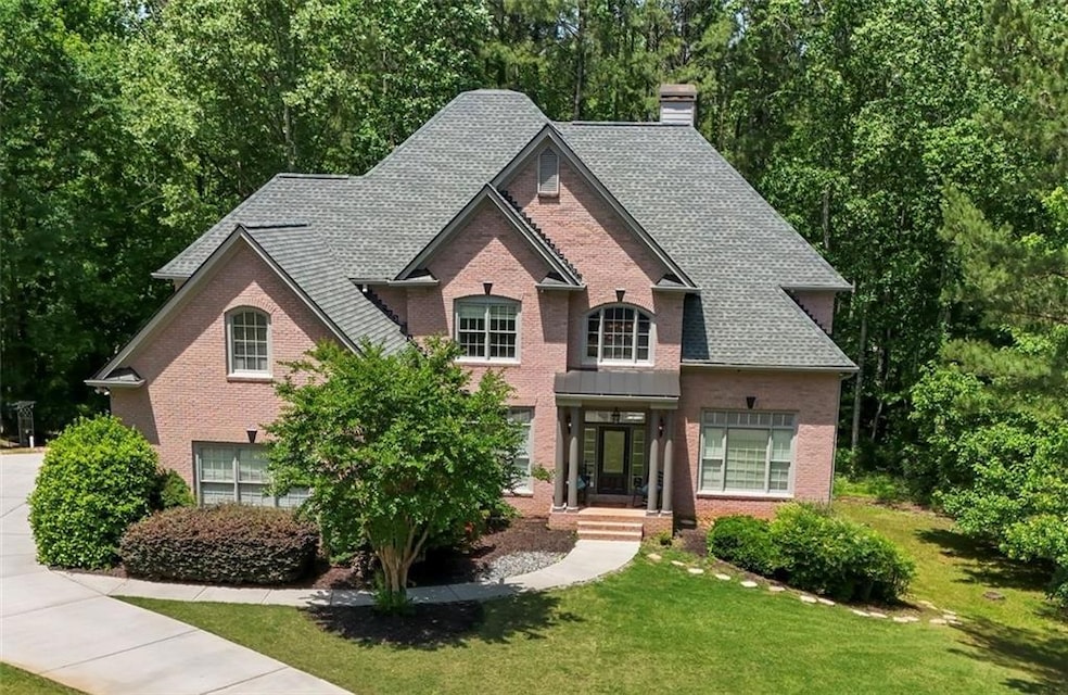 View of front of house with a chimney, a front lawn, and brick siding