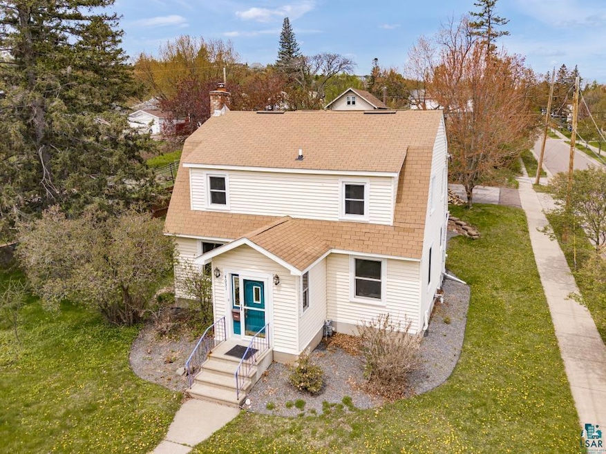 Dutch colonial featuring roof with shingles, a front lawn, and a chimney