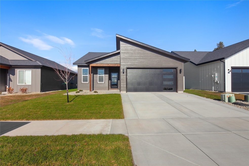 View of front of house with a front lawn, driveway, and a garage