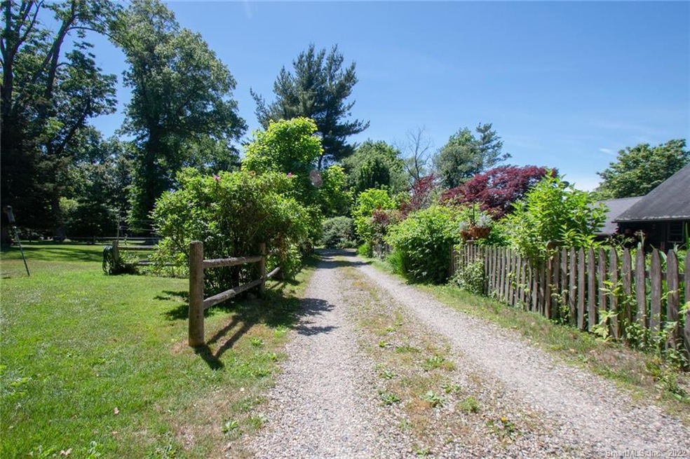 Beautiful gravel entrance with mature plantings.