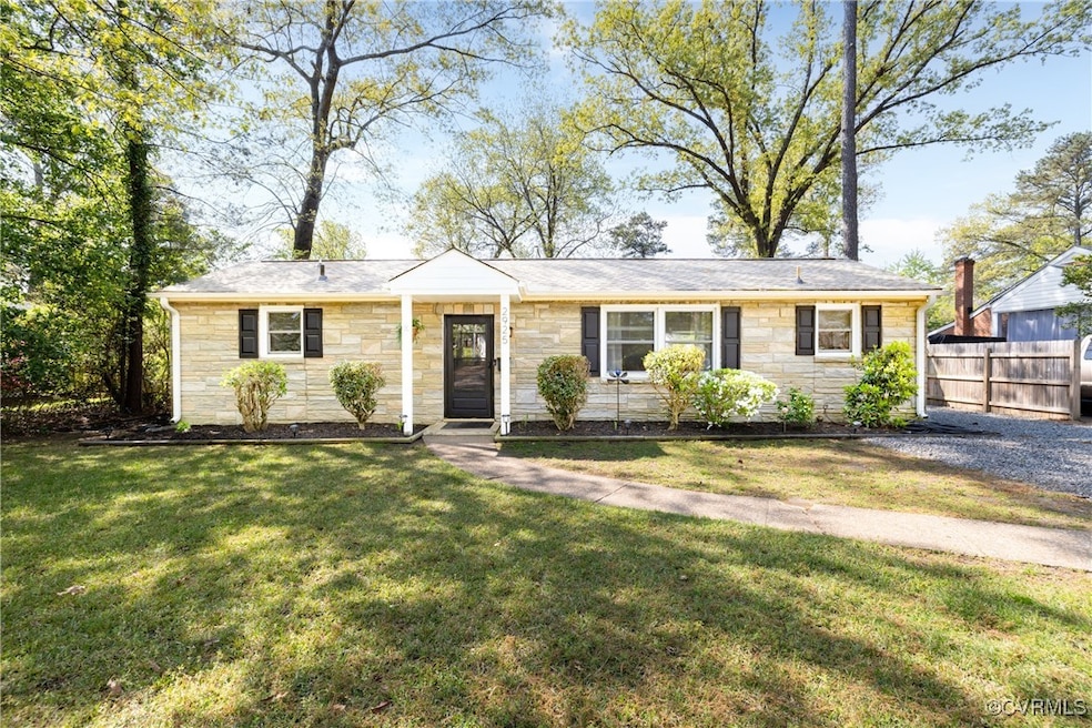 Single story home with stone siding, fence, and a
