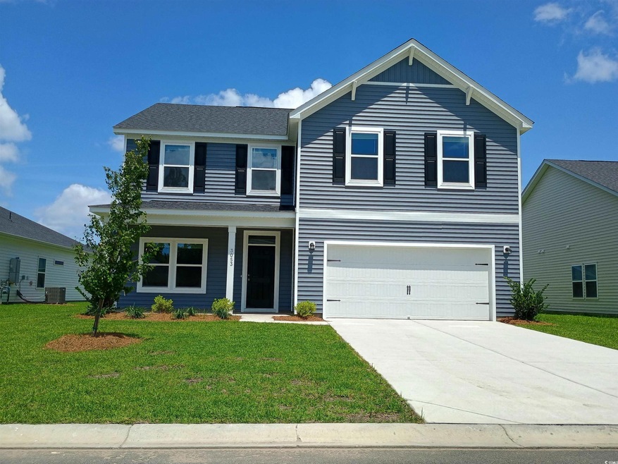 Traditional-style house with a front lawn, concrete driveway, an attached garage, and a porch