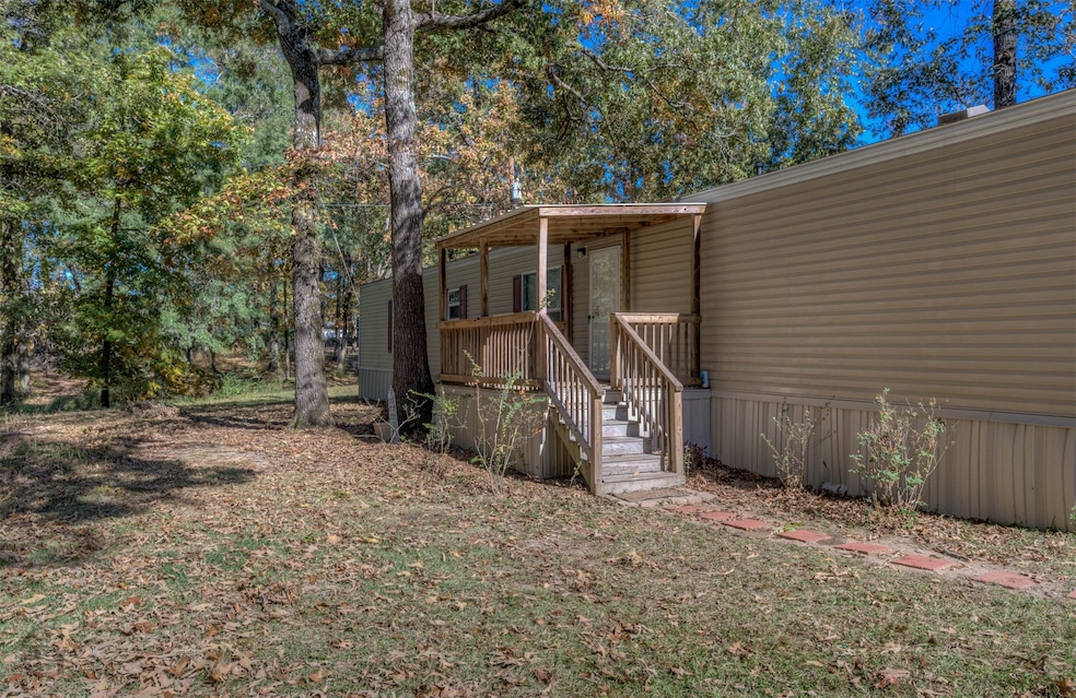 View of home's exterior featuring a deck and view of scattered trees