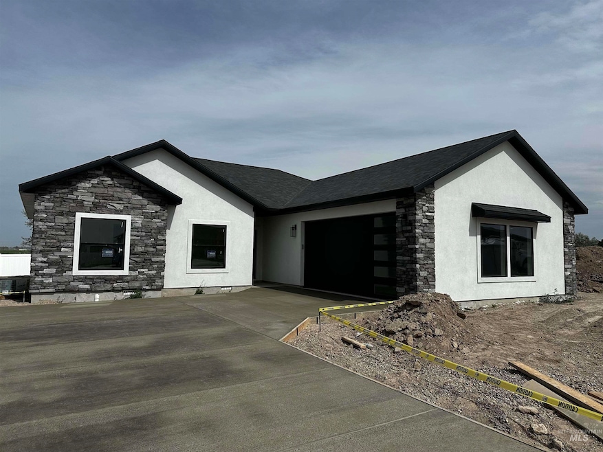 Single story home with stone siding, concrete driveway, an attached garage, and stucco siding