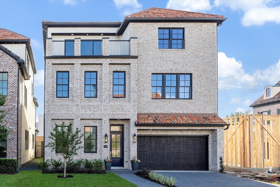 Beautiful brick home with a driveway and rooftop d