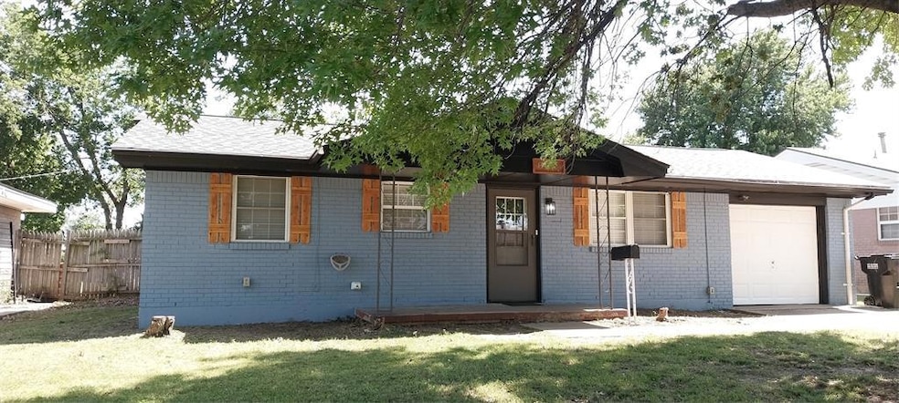 Ranch-style house featuring a garage and brick sid