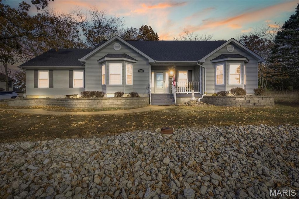 Single story home with a porch and a shingled roof