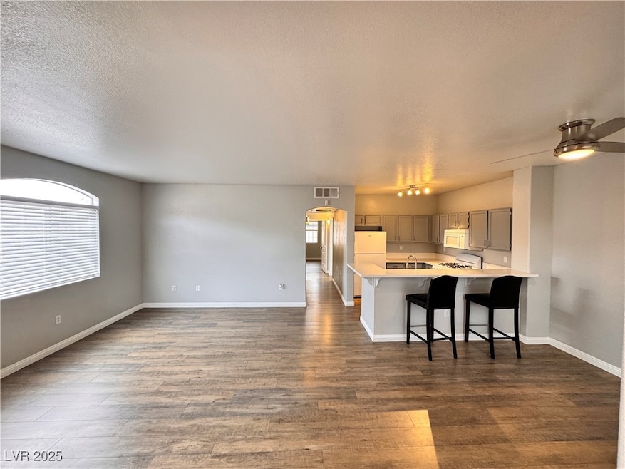 Kitchen with white microwave, visible vents, gray