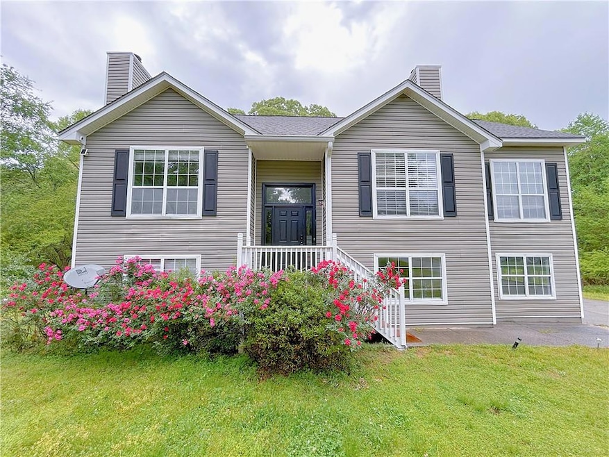 Bi-level home featuring a chimney and a front yard