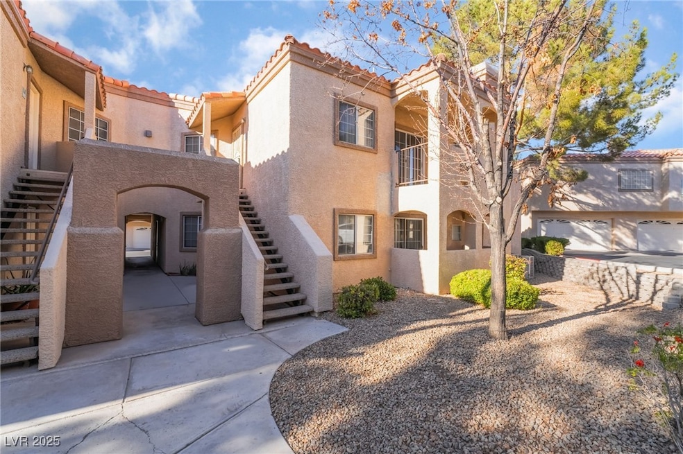 View of front of home with stairs, a tile roof, an