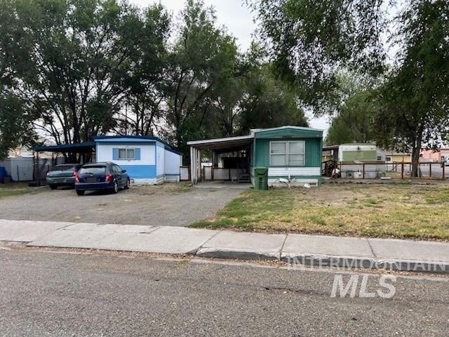 Manufactured / mobile home featuring asphalt driveway and an attached carport