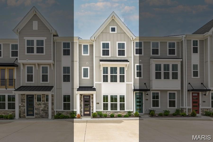 View of front of house featuring stone siding, board and batten siding, and a residential view