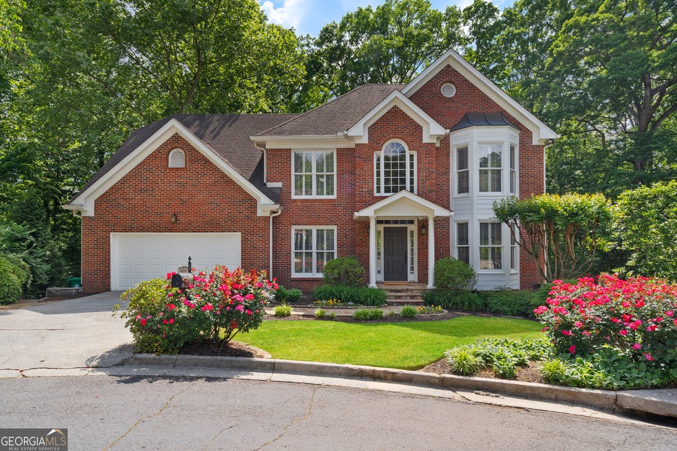 Colonial home with concrete driveway, brick siding