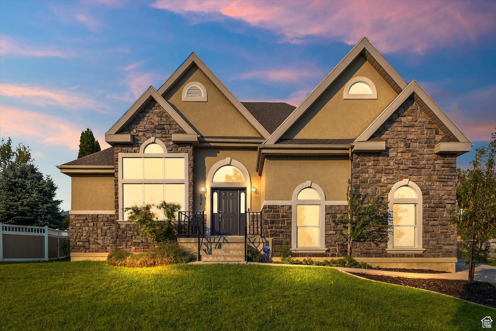 View of front of home with stone siding, stucco siding, and a shingled roof