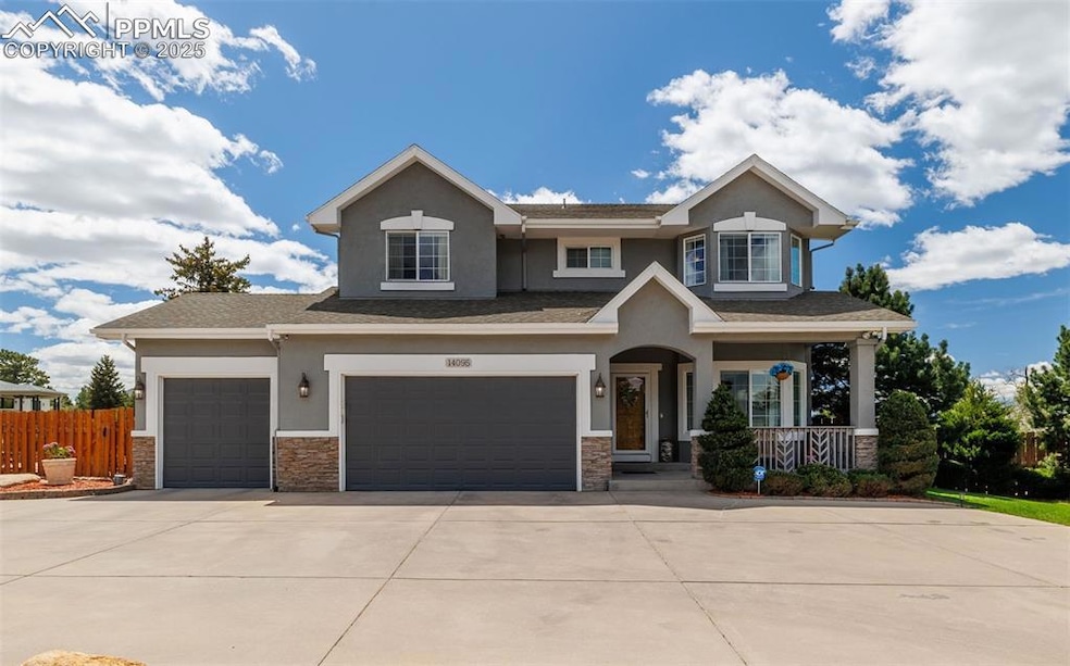 Craftsman-style house with driveway, stucco siding, covered porch, stone siding, and an attached garage