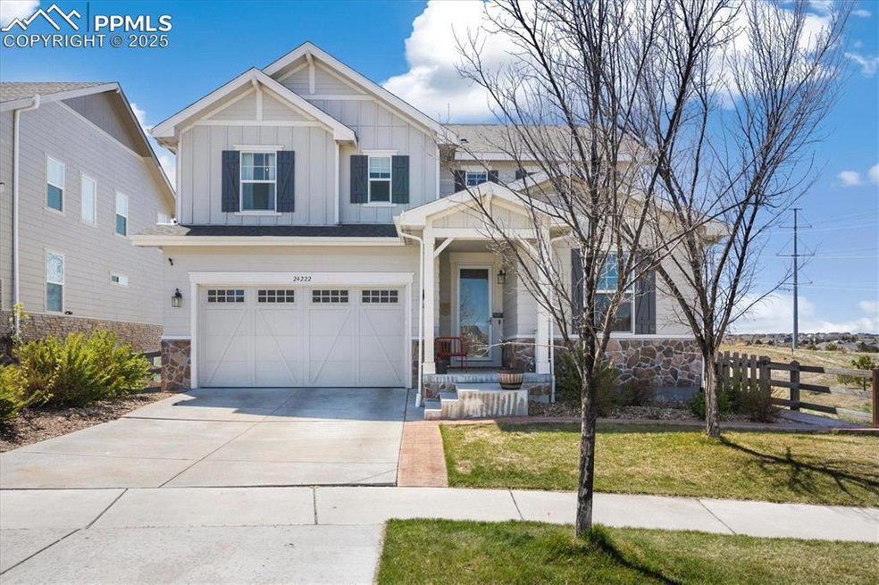 Craftsman-style house with concrete driveway, stone siding, board and batten siding, an attached garage, and fence