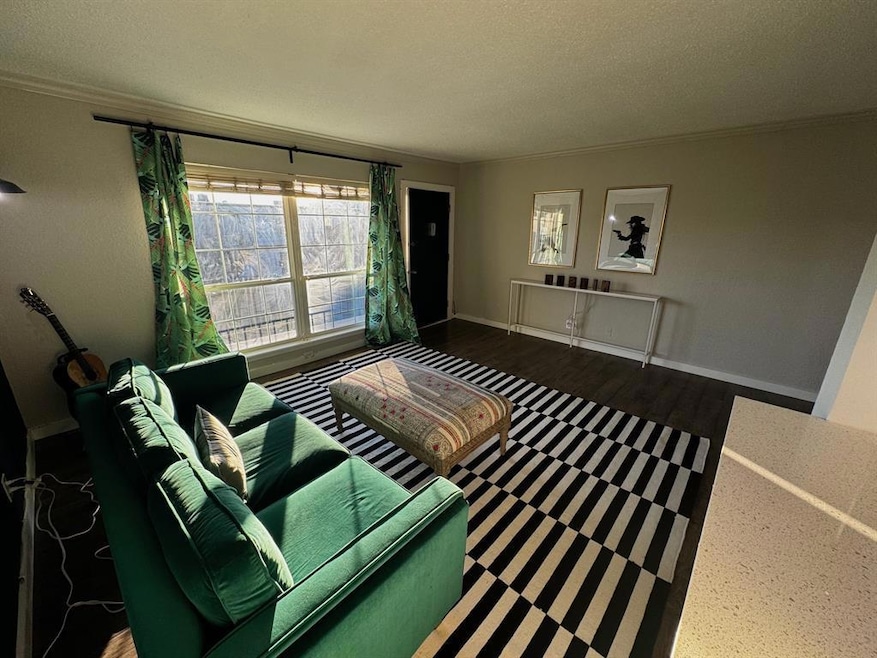 Living area with crown molding, baseboards, a tex