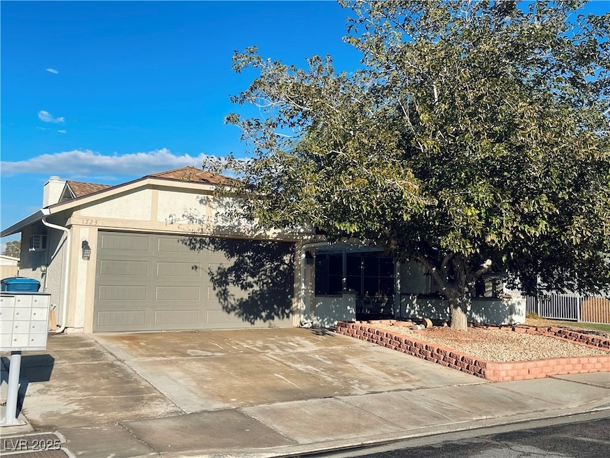 View of front facade featuring driveway, stucco siding, and an attached garage