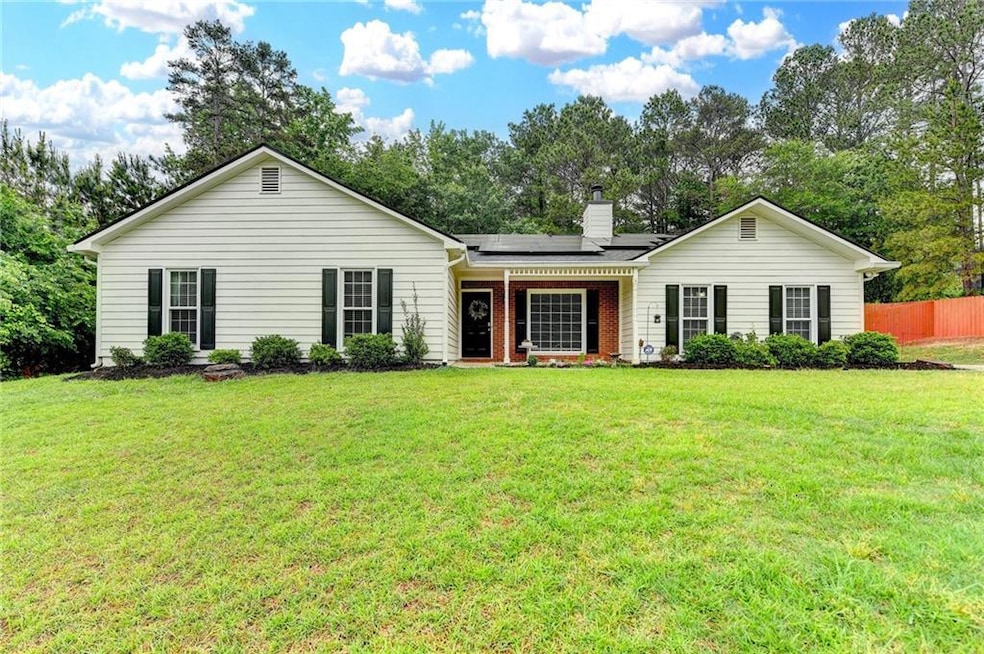 Ranch-style house featuring fence, solar panels, a