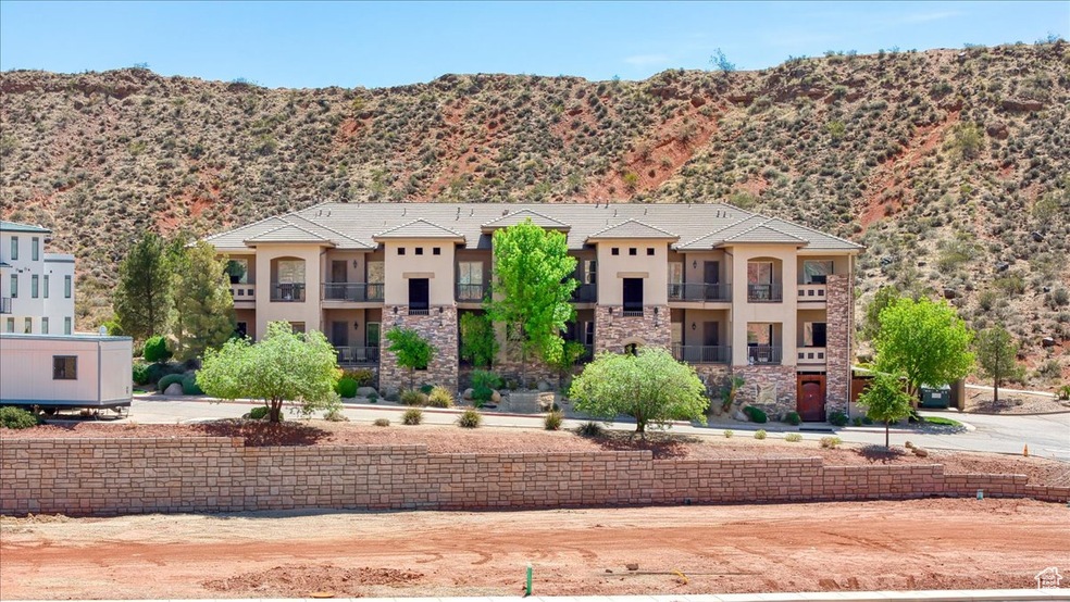 View of front facade with a balcony, stone siding, stucco siding, and a mountain view