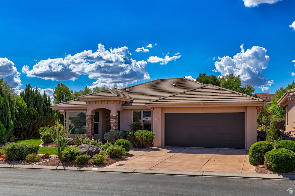 View of front of house featuring stucco siding, concrete driveway, a garage, and a tiled roof