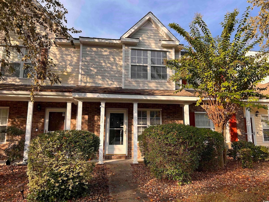 View of front facade with brick siding and a porch