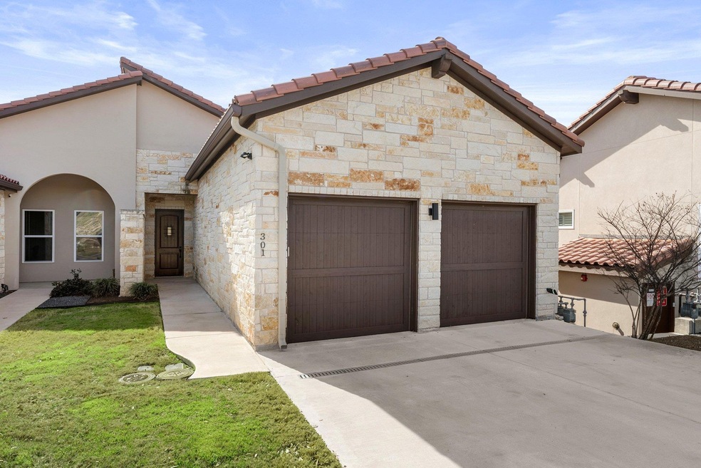 View of front of property with a garage, stone si