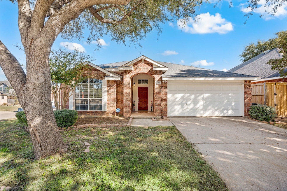 View of front of home with concrete driveway, brick siding, a shingled roof, and a garage