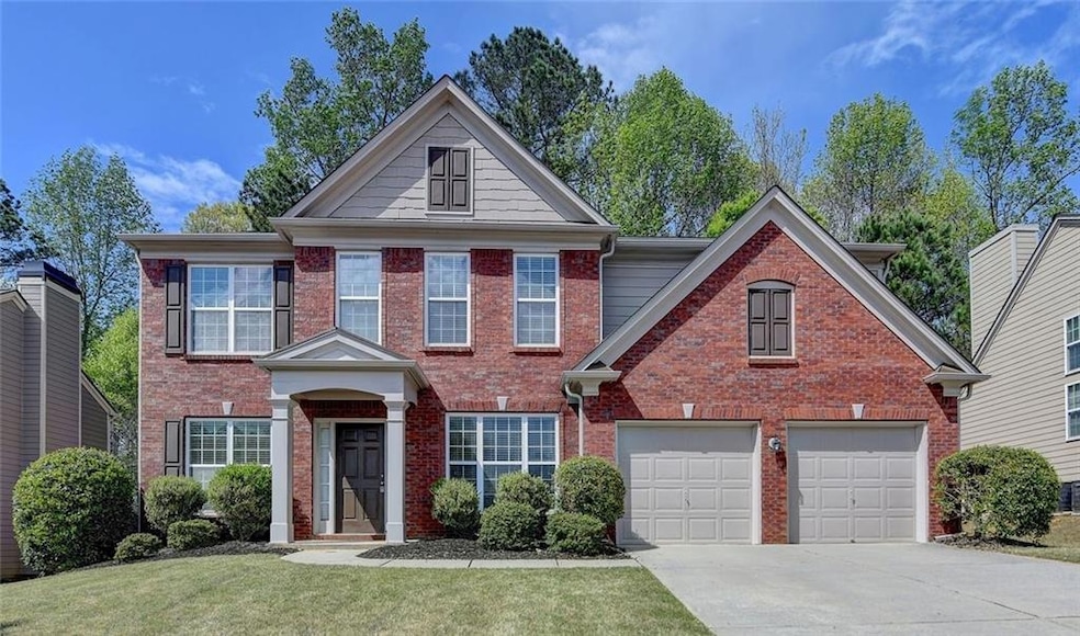 View of front of home featuring driveway, brick siding, and a front yard