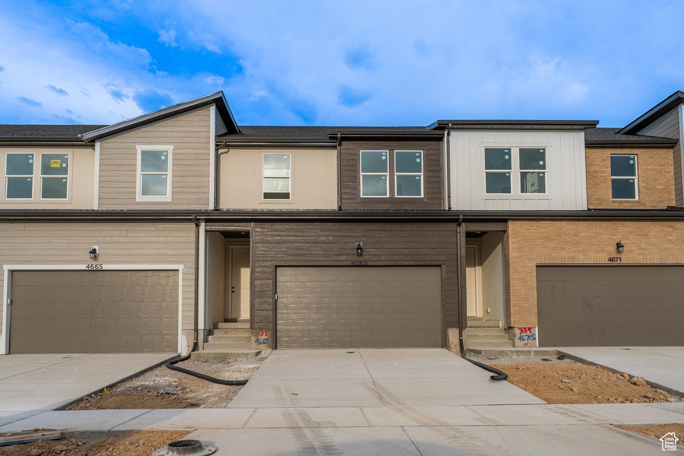 Multi unit property featuring a garage, driveway, and entry steps