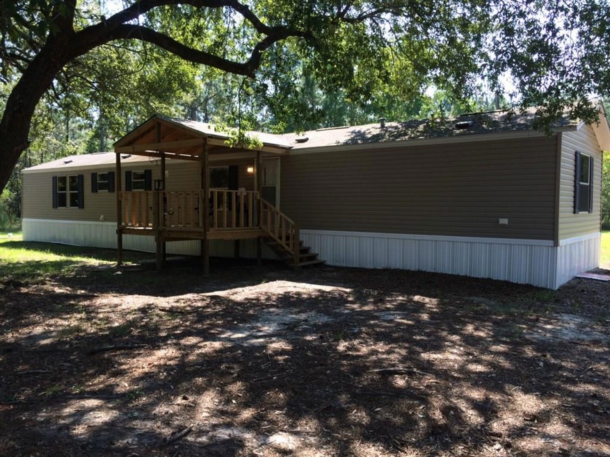 View of home, raised porch, and oak trees.