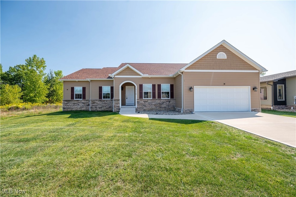 Craftsman house with driveway, a front lawn, stone siding, an attached garage, and a shingled roof