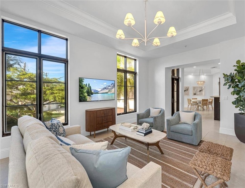 Tiled living room with crown molding, a tray ceili