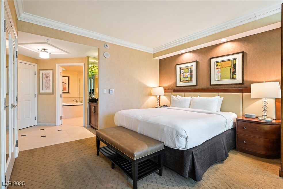 Bedroom with crown molding and connected bathroom