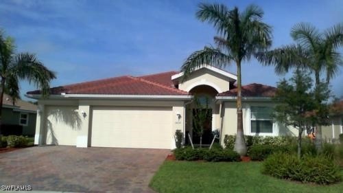 Ranch-style house with an attached garage and asph