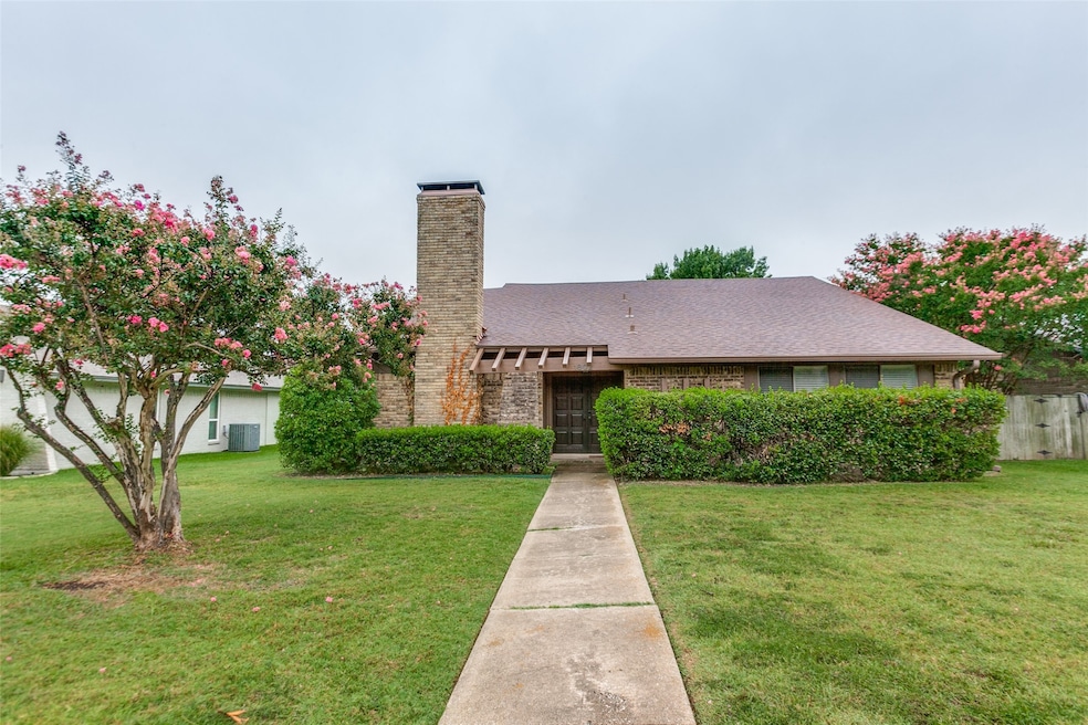 View of front of property featuring a chimney, brick siding, and a shingled roof